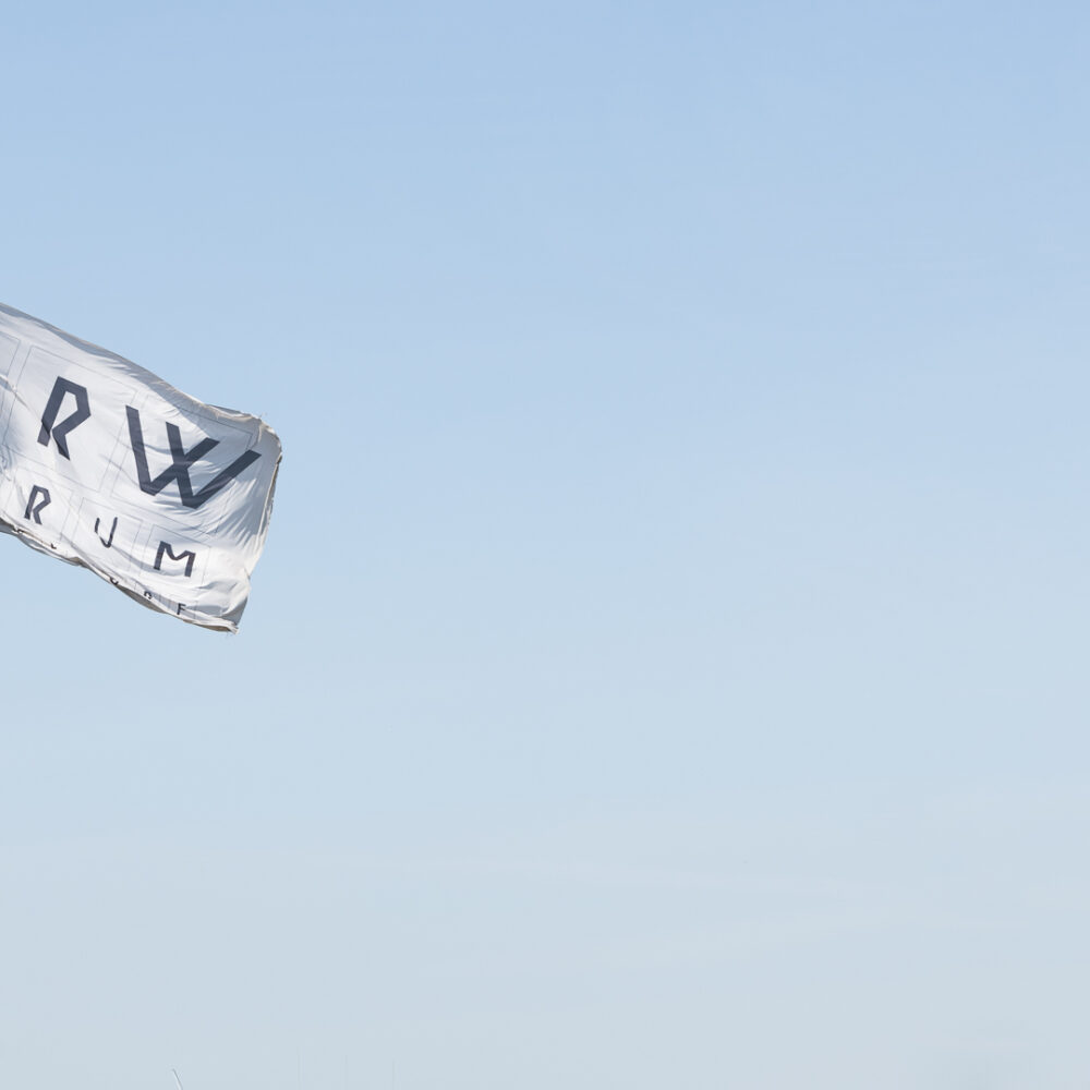 Flagge mit Logo des NRW Forums vor blauem Himmel