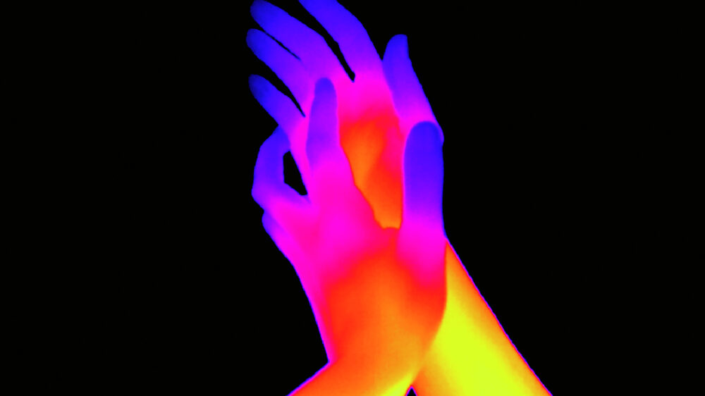 Two touching hands in bright colours, which merge into each other, on black background