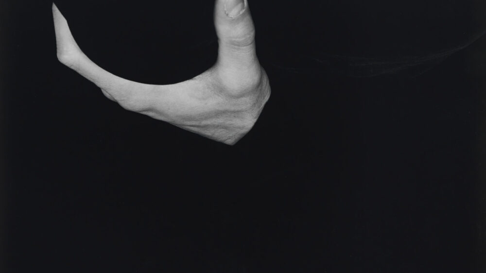 Cutout of a hand in black and white on black background.