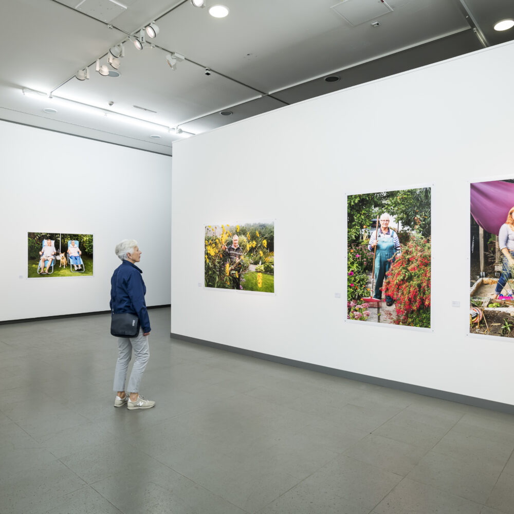 Eine Person betrachtet in der Martin Parr Retrospektive Bilder des Fotografen