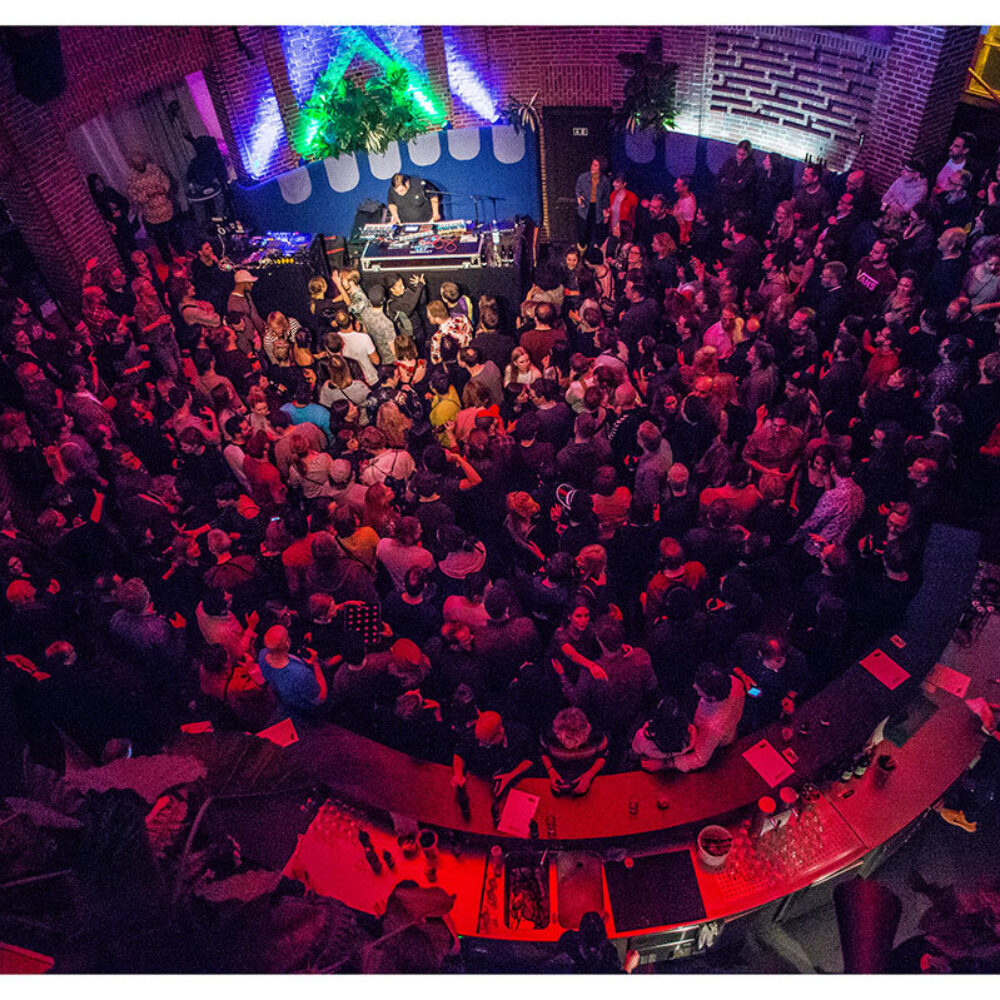 Concert with many people in the audience and a musician on stage in the rotunda of the NRW Forum